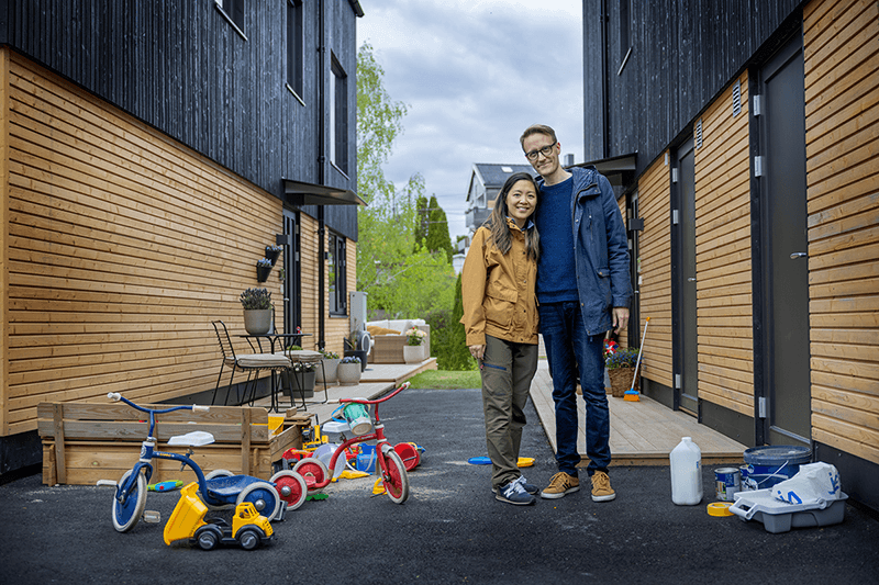 Par står utenfor huset omgitt av barneleker