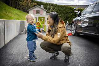 Mamma setter seg på huk ved siden av barnet