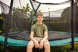 Gutt sitter på trampoline