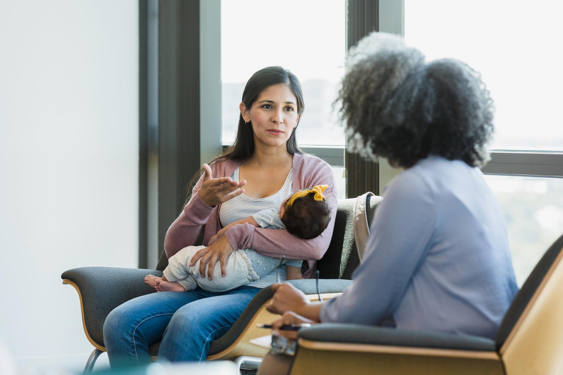 illutsrtaion: to womet talking, one of them holding a baby