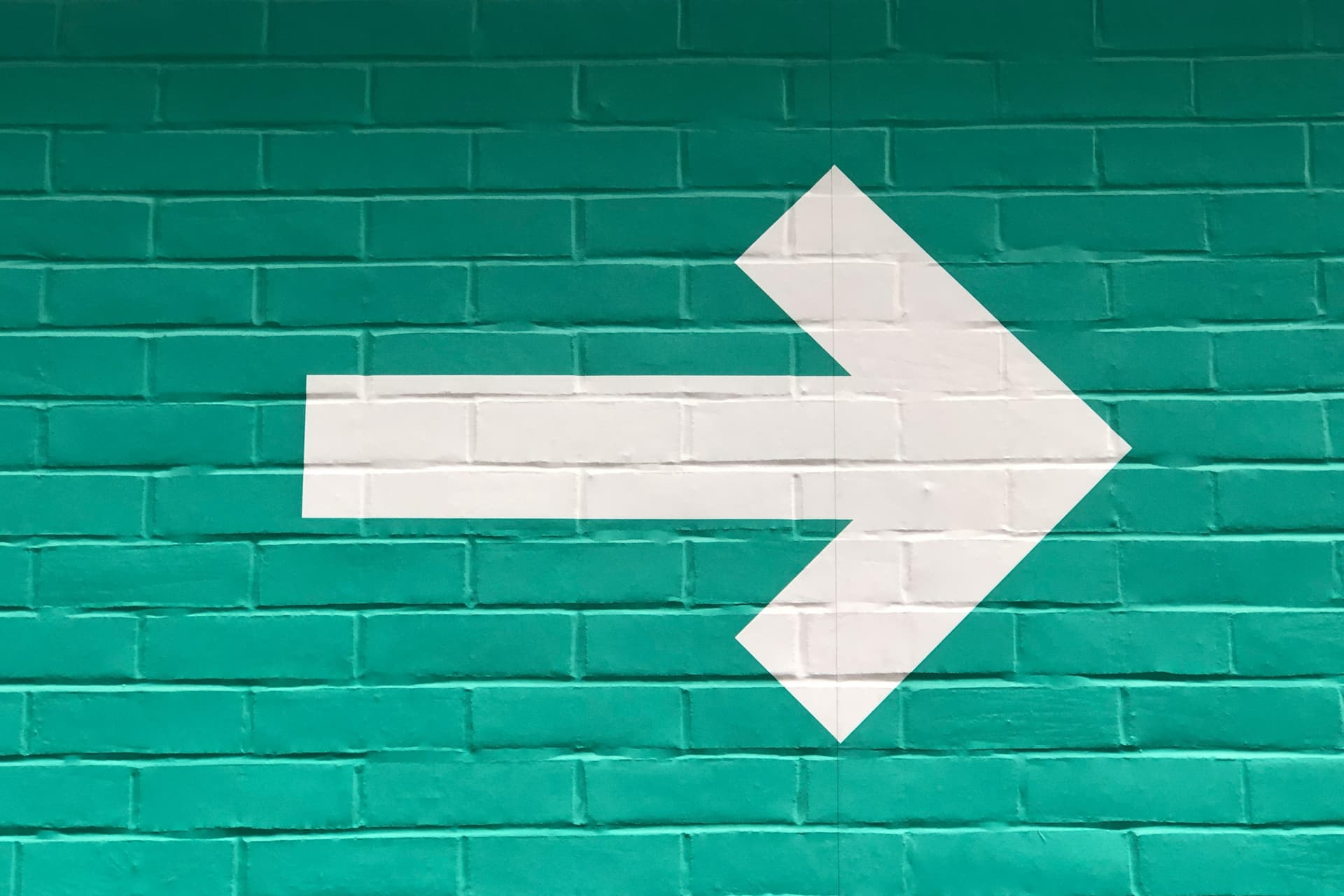 Hvit pil på grønn bakgrunn