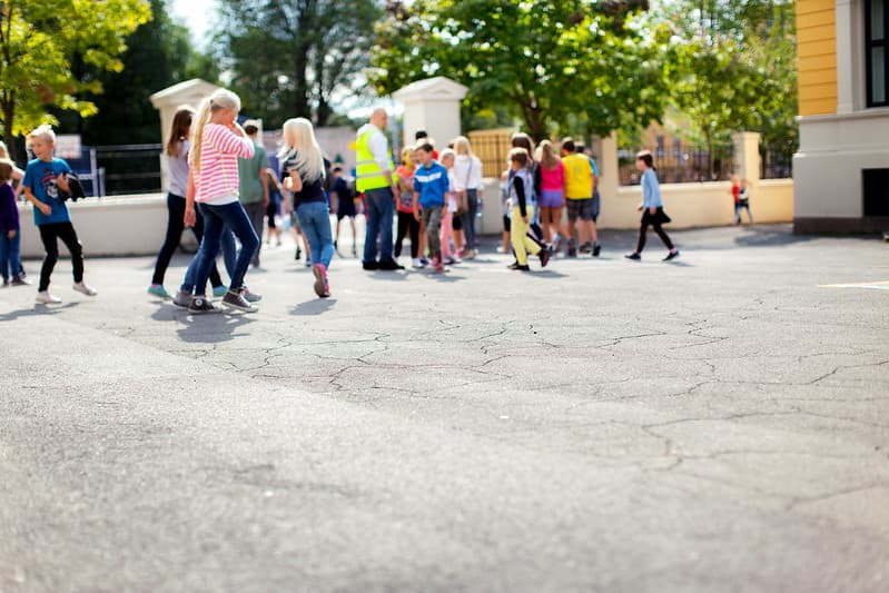 Barn som går rundt i en skolegård.