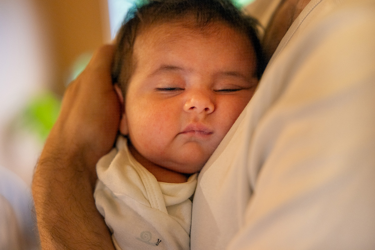 Baby hviler mot brystet til pappa.