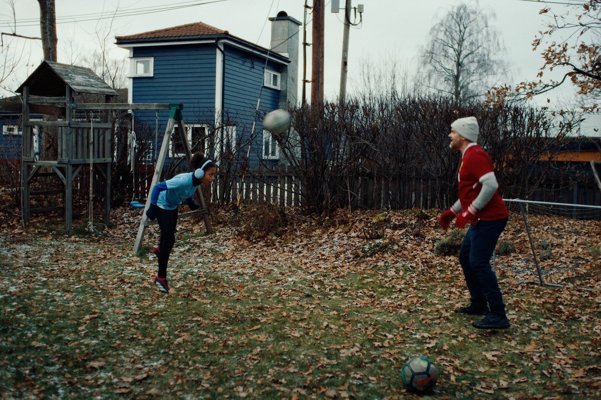 en jente og en mann spiller fotball ute. illustrasjonsbilde